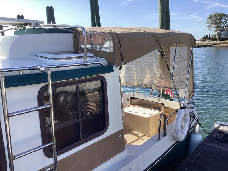 Slide: The Image of 2012 Ranger Tugs R-27 boat docked with canopy and ladder. - 6