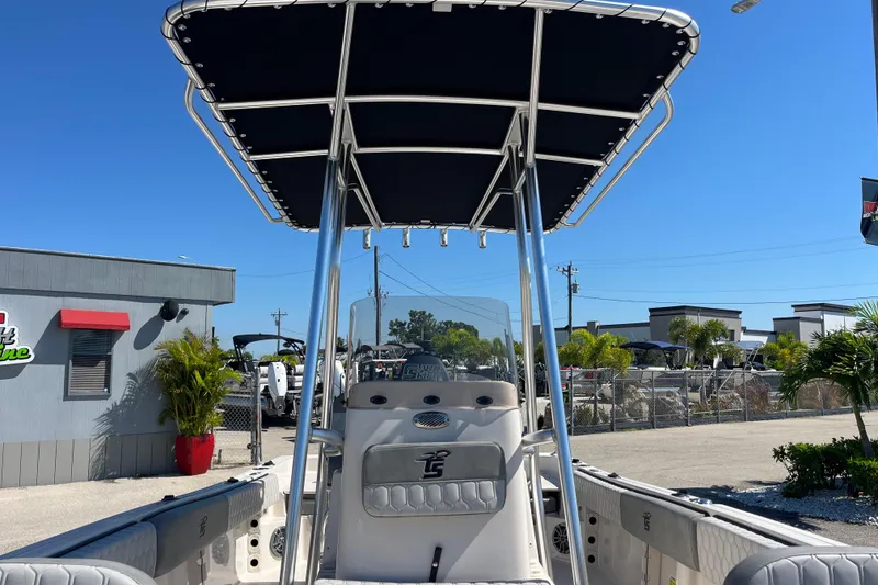 Slide: The Image of 2025 Carolina Skiff 21 Ultra Elite boat with T-top, parked outdoors under clear blue sky. - 14