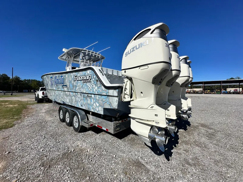 Slide: The Image of 2016 Freeman 37VH boat with Suzuki engines on a trailer in a parking lot. - 11