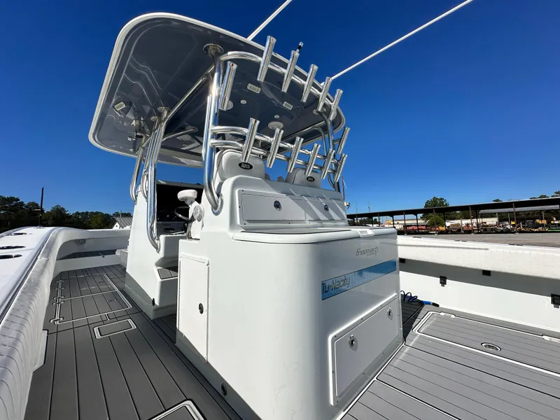 Slide: The Image of 2016 Freeman 37VH boat with sleek design and spacious deck under clear blue sky. - 23