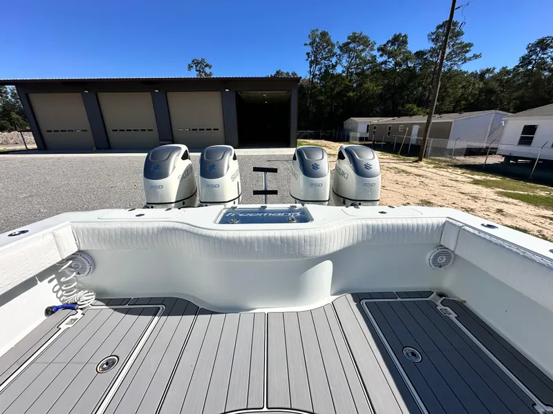 Slide: The Image of 2016 Freeman 37VH boat with four outboard engines, docked near storage units. - 37