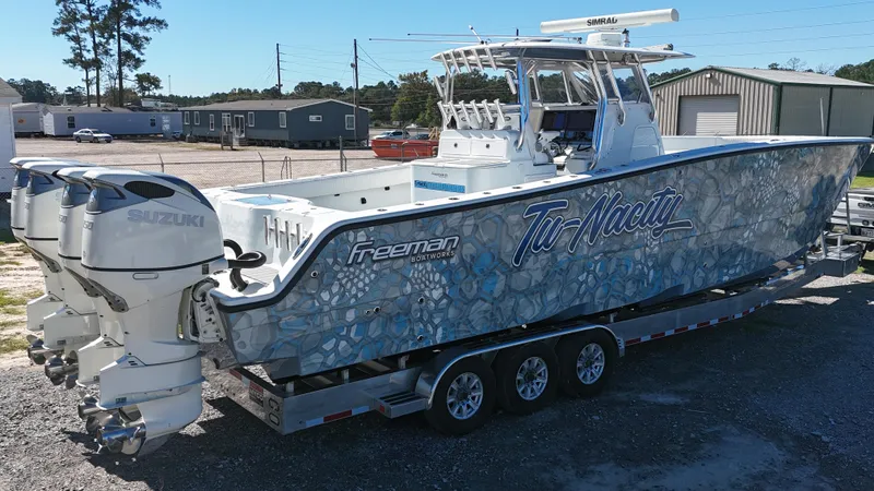 Slide: The Image of Freeman 37VH 2016 boat with custom graphics on a trailer, featuring Suzuki outboard engines. - 5