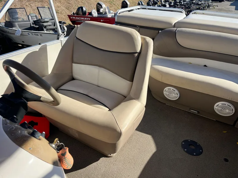Slide: The Image of 2001 Sun Tracker PARTY BARGE 25 boat interior with beige seating and steering wheel. - 23