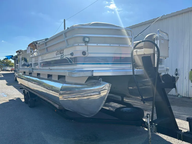 Slide: The Image of 2001 Sun Tracker PARTY BARGE 25 pontoon boat on trailer, parked outdoors. - 5