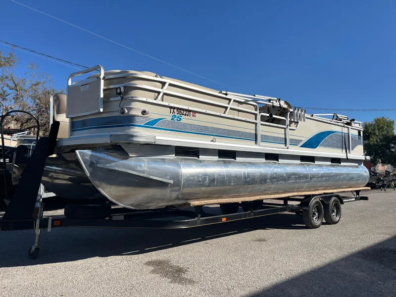 Slide: The Image of 2001 Sun Tracker PARTY BARGE 25 pontoon boat on a trailer, parked outdoors. - 6