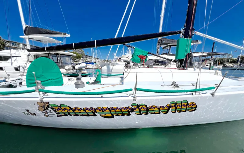 Slide: The Image of White sailboat named "Margaritaville" docked in marina, Custom Modified In 2003 SLP 52, 1989 model - 4