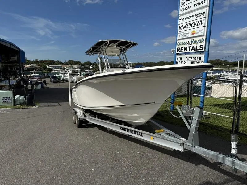 Slide: The Image of 2025 Key West 244 CC boat on trailer at marina, sunny day. - 2