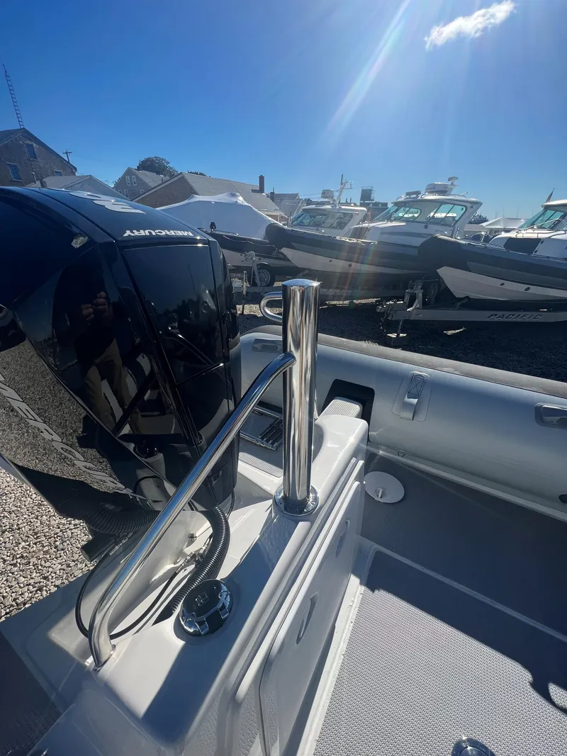 Slide: The Image of 2023 Protector 250 Chase boat with outboard motor in a sunny marina. - 14