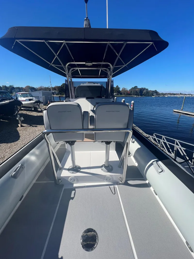 Slide: The Image of 2023 Protector 250 Chase boat with canopy, docked by a serene lake. - 15