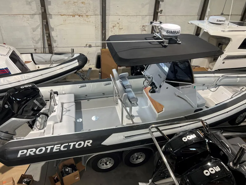 Slide: The Image of 2023 Protector 250 Chase boat in showroom, featuring sleek design and advanced navigation equipment. - 17