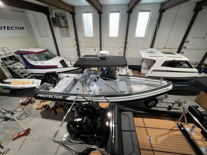 Slide: The Image of 2023 Protector 250 Chase boat in a showroom with other vessels. - 4