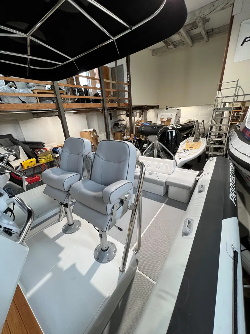 Slide: The Image of 2023 Protector 250 Chase boat interior with dual seats in a storage facility. - 5