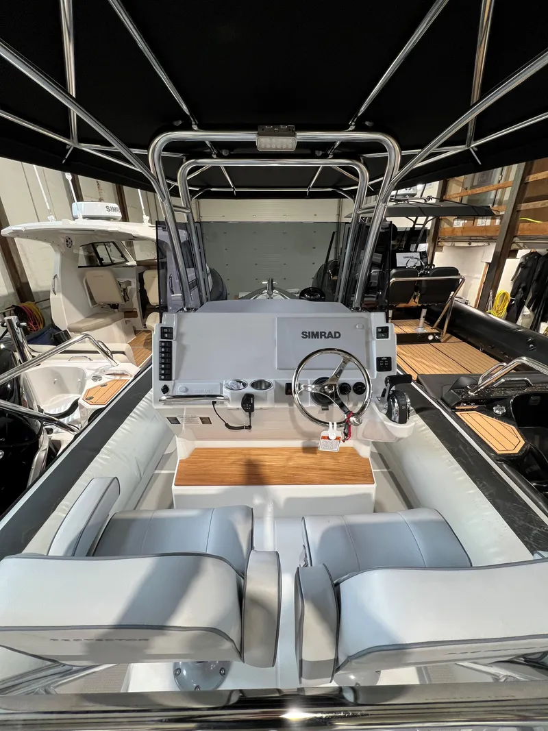 Slide: The Image of 2023 Protector 250 Chase boat interior with modern steering console and seating. - 7