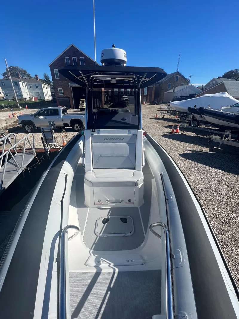 Slide: The Image of 2023 Protector 250 Chase boat with sleek design, docked under clear blue sky. - 8