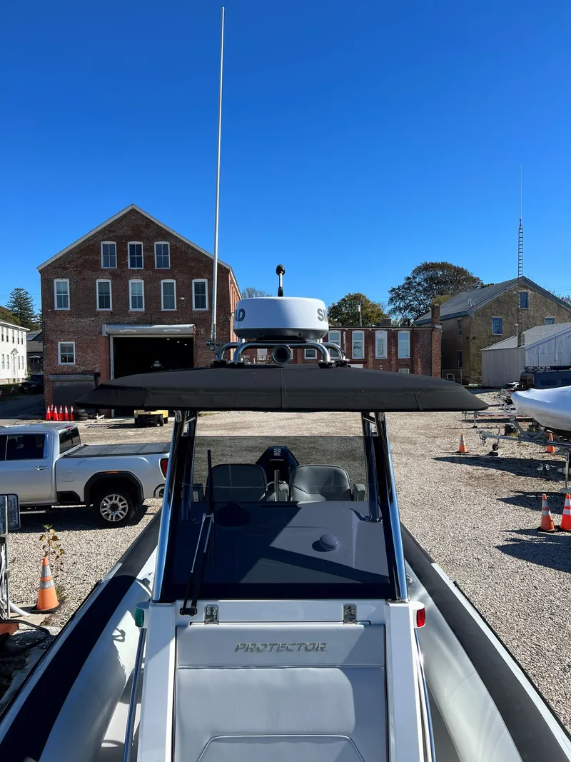 Slide: The Image of 2023 Protector 250 Chase boat in a marina with historic buildings in the background. - 9