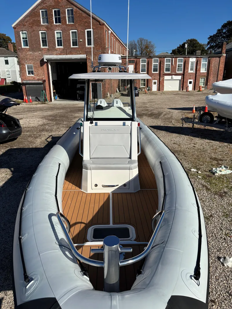 Slide: The Image of 2024 Protector 330 Chase boat with sleek design, docked near brick buildings. - 11