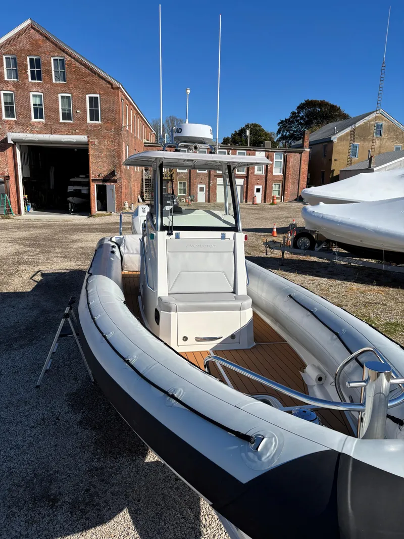 Slide: The Image of 2024 Protector 330 Chase boat docked near historic brick buildings. - 12