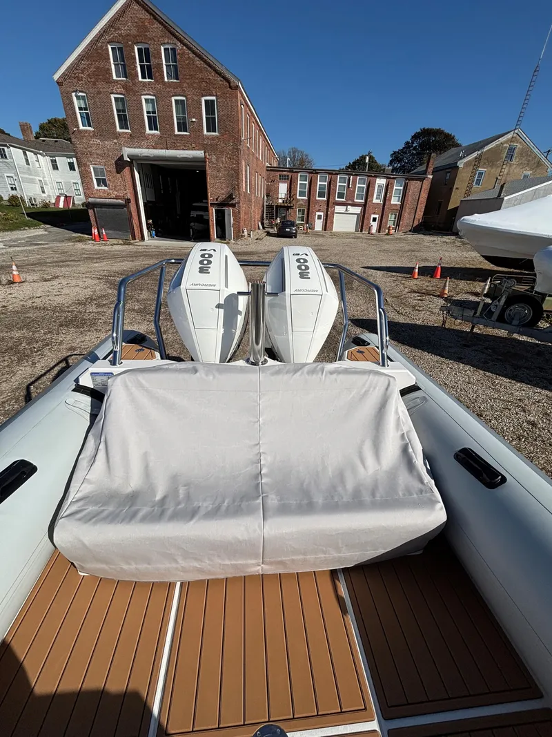 Slide: The Image of 2024 Protector 330 Chase boat with twin engines, docked near historic brick buildings. - 15