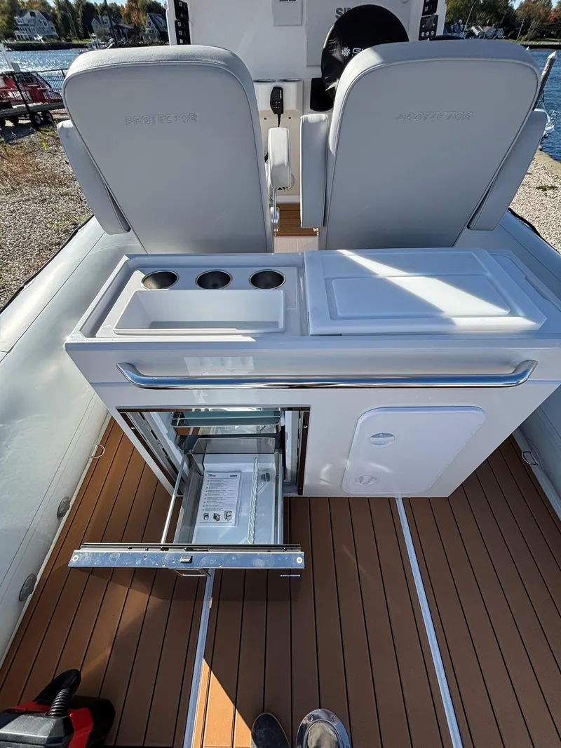 Slide: The Image of 2024 Protector 330 Chase boat interior with seating and storage compartments. - 19