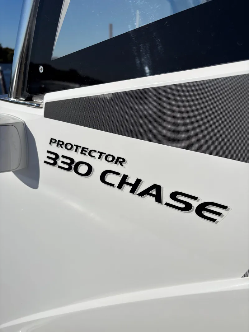 Slide: The Image of 2024 Protector 330 Chase boat model name on white exterior. - 25