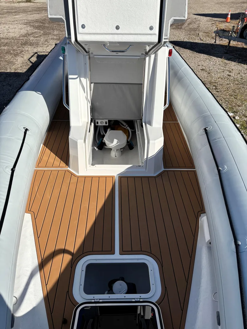 Slide: The Image of 2024 Protector 330 Chase boat interior with wood deck and open hatch. - 29