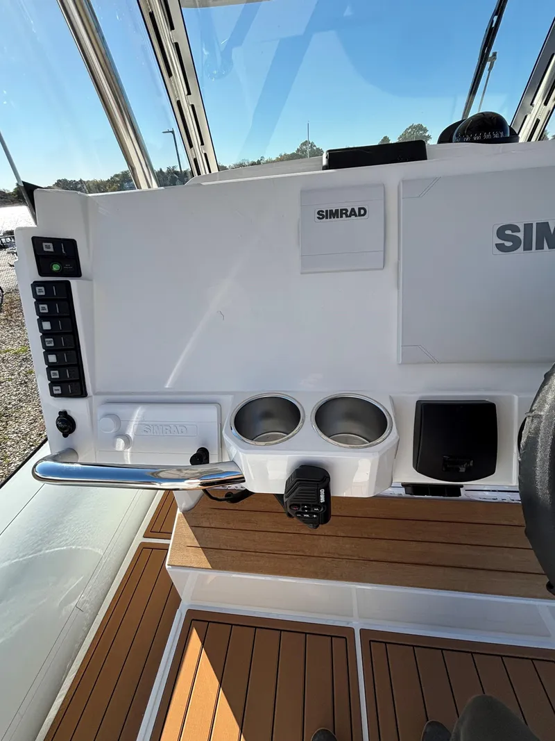 Slide: The Image of Protector 330 Chase 2024 boat dashboard with Simrad electronics and cup holders. - 7