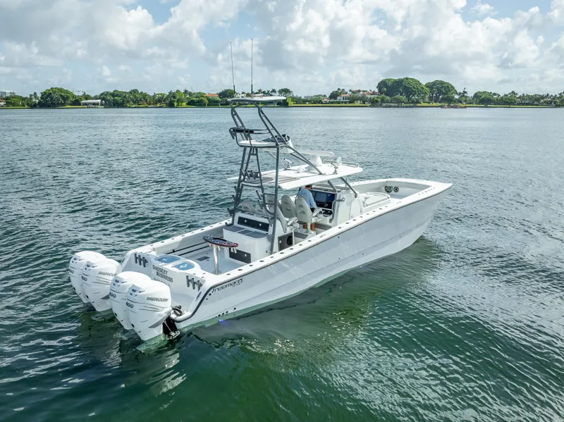 Slide: The Image of 2020 Freeman 42 LR boat on calm water with triple outboard engines. - 13