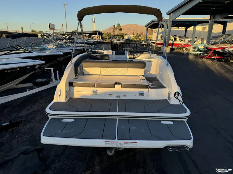 Slide: The Image of 2020 Bayliner DX2250 boat with spacious deck and seating, displayed in a marina. - 2
