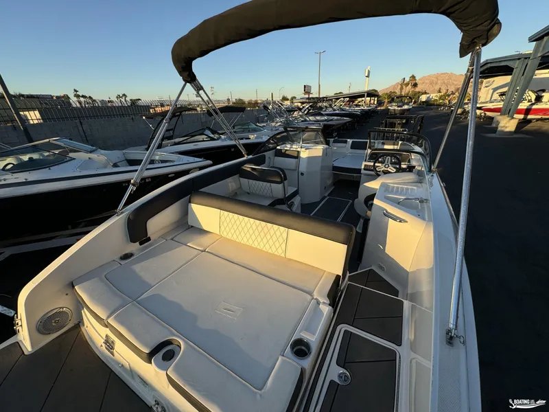 Slide: The Image of 2020 Bayliner DX2250 boat interior with seating and steering wheel, docked at marina. - 3