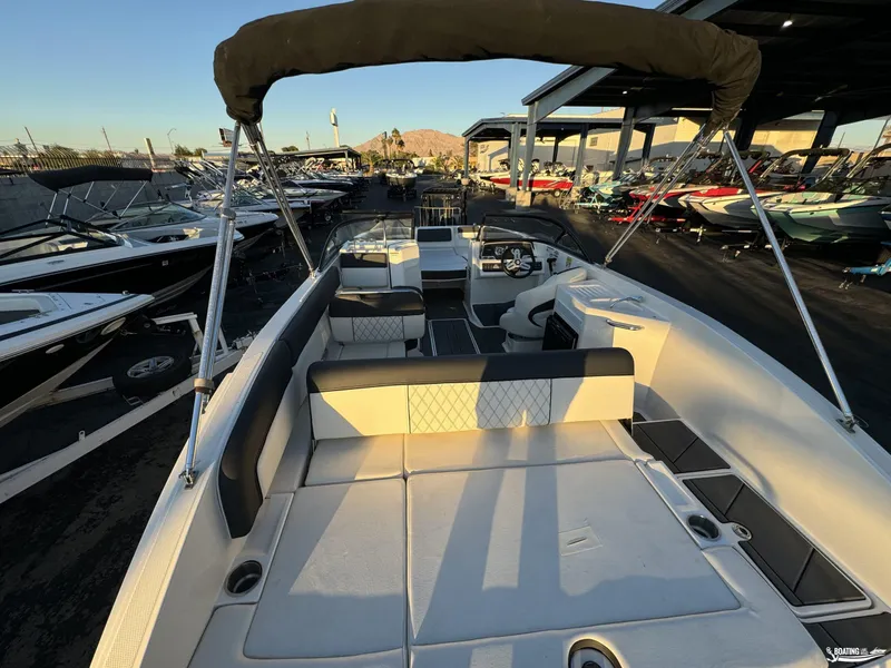 Slide: The Image of 2020 Bayliner DX2250 boat interior with seating and steering wheel, docked at marina. - 4