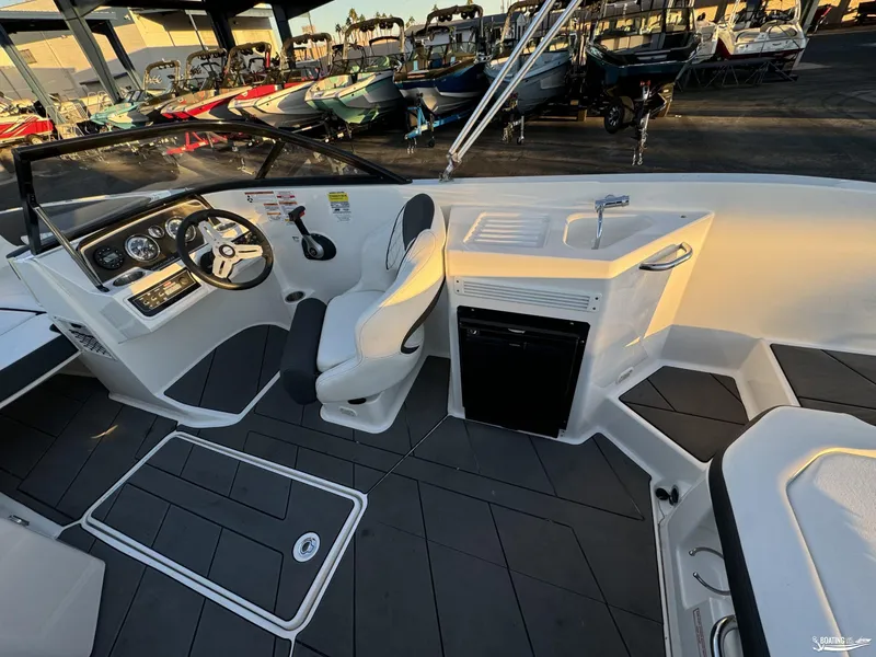 Slide: The Image of 2020 Bayliner DX2250 boat interior with steering wheel and seating area. - 8