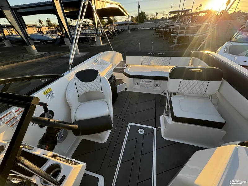 Slide: The Image of 2020 Bayliner DX2250 boat interior with seating and steering wheel at sunset. - 9