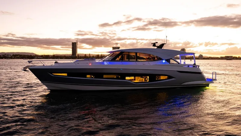 Slide: The Image of 2025 Riviera 6800 Sport Yacht Platinum Edition at sunset on the water. - 0