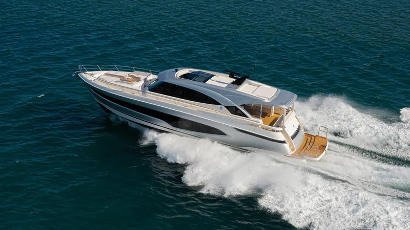 Slide: The Image of 2025 Riviera 6800 Sport Yacht Platinum Edition cruising on open water. - 1