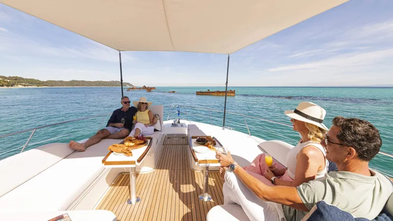 Slide: The Image of People relaxing on a 2025 Riviera 6800 Sport Yacht Platinum Edition, enjoying the ocean view. - 11