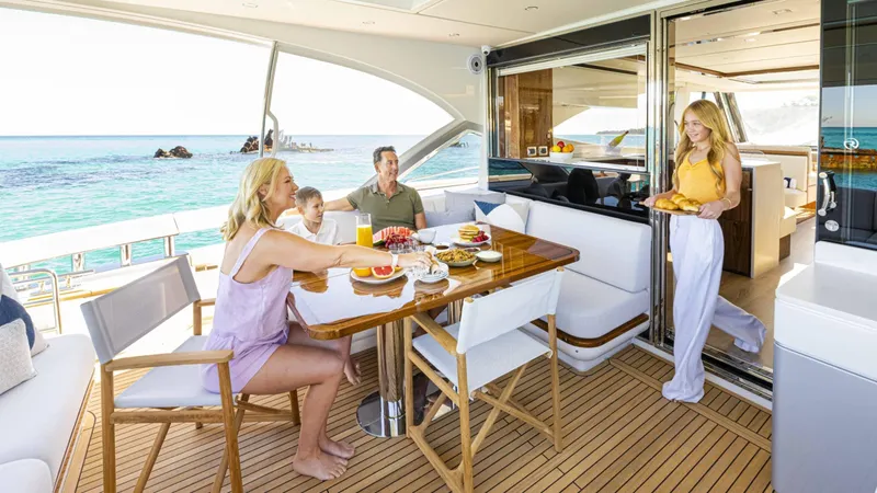 Slide: The Image of Family enjoying breakfast on 2025 Riviera 6800 Sport Yacht Platinum Edition. - 12
