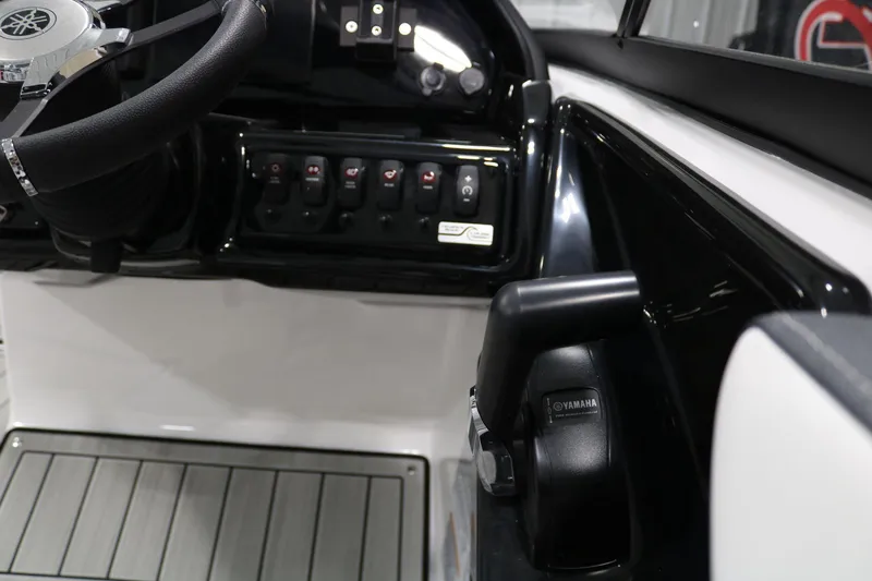 Slide: The Image of 2025 Yamaha Boats 195S steering console with controls and switches. - 24