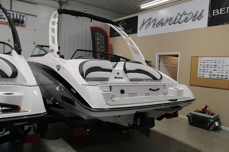 Slide: The Image of 2025 Yamaha Boats 195S in showroom, rear view, sleek design, white and black color scheme. - 5