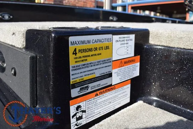 Slide: The Image of 2018 Triton 21 TrX boat capacity label, maximum 4 persons or 675 lbs, safety warnings visible. - 21