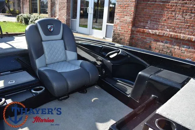 Slide: The Image of 2018 Triton 21 TrX boat interior with gray seating and Thayer's Marine logo. - 23
