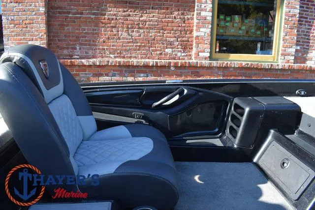 Slide: The Image of 2018 Triton 21 TrX boat interior with gray seating and Thayer's Marine logo. - 24