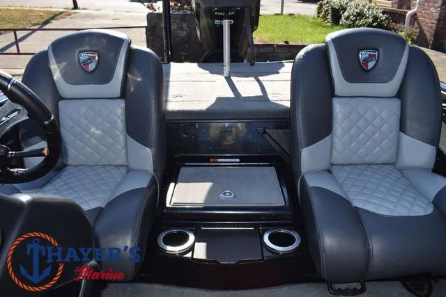 Slide: The Image of 2018 Triton 21 TrX boat interior with dual gray seats and Thayer's Marine logo. - 26