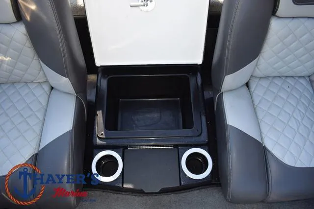 Slide: The Image of 2018 Triton 21 TrX boat interior with storage compartment and cup holders. - 27