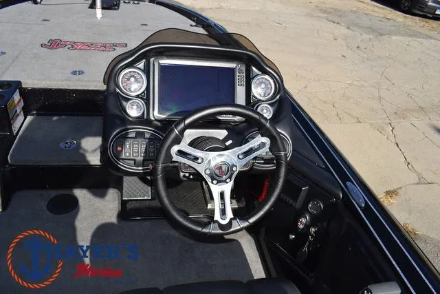 Slide: The Image of 2018 Triton 21 TrX boat dashboard with steering wheel and control panel. - 30