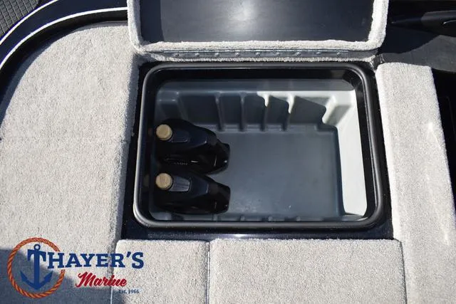 Slide: The Image of Triton 21 TrX 2018 boat storage compartment with two bottles, Thayer's Marine logo visible. - 36