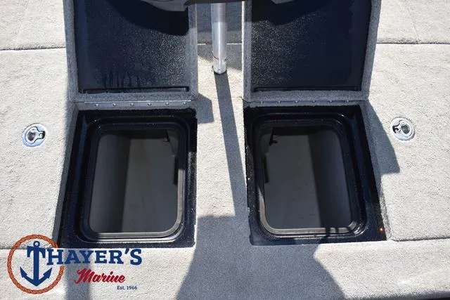 Slide: The Image of Open storage compartments on a 2018 Triton 21 TrX boat deck, Thayer's Marine logo visible. - 37