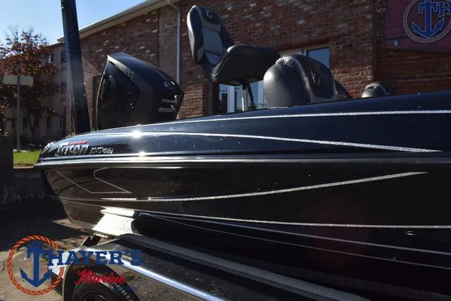 Slide: The Image of 2018 Triton 21 TrX boat with sleek black design, displayed outdoors. - 43