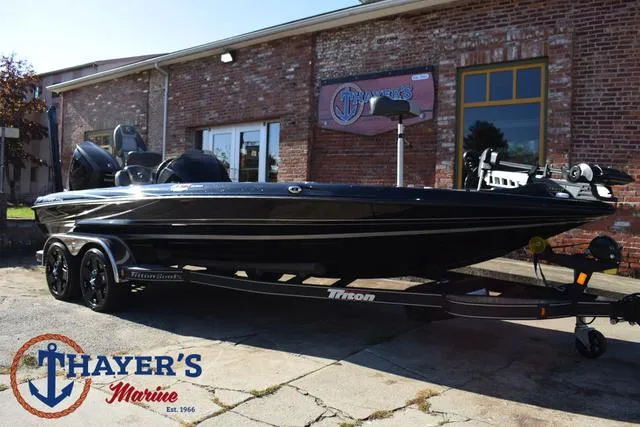 Slide: The Image of 2018 Triton 21 TrX boat at Thayer's Marine dealership, parked outdoors. - 44