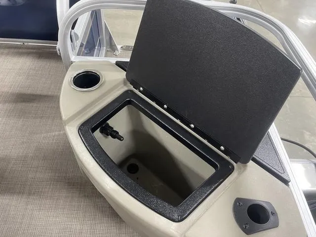 Slide: The Image of 2025 Sun Tracker BASS BUGGY® 18 DLX boat storage compartment with open lid and cup holder. - 27