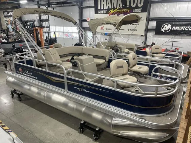 Slide: The Image of 2025 Sun Tracker Bass Buggy 18 DLX pontoon boat in showroom. - 3